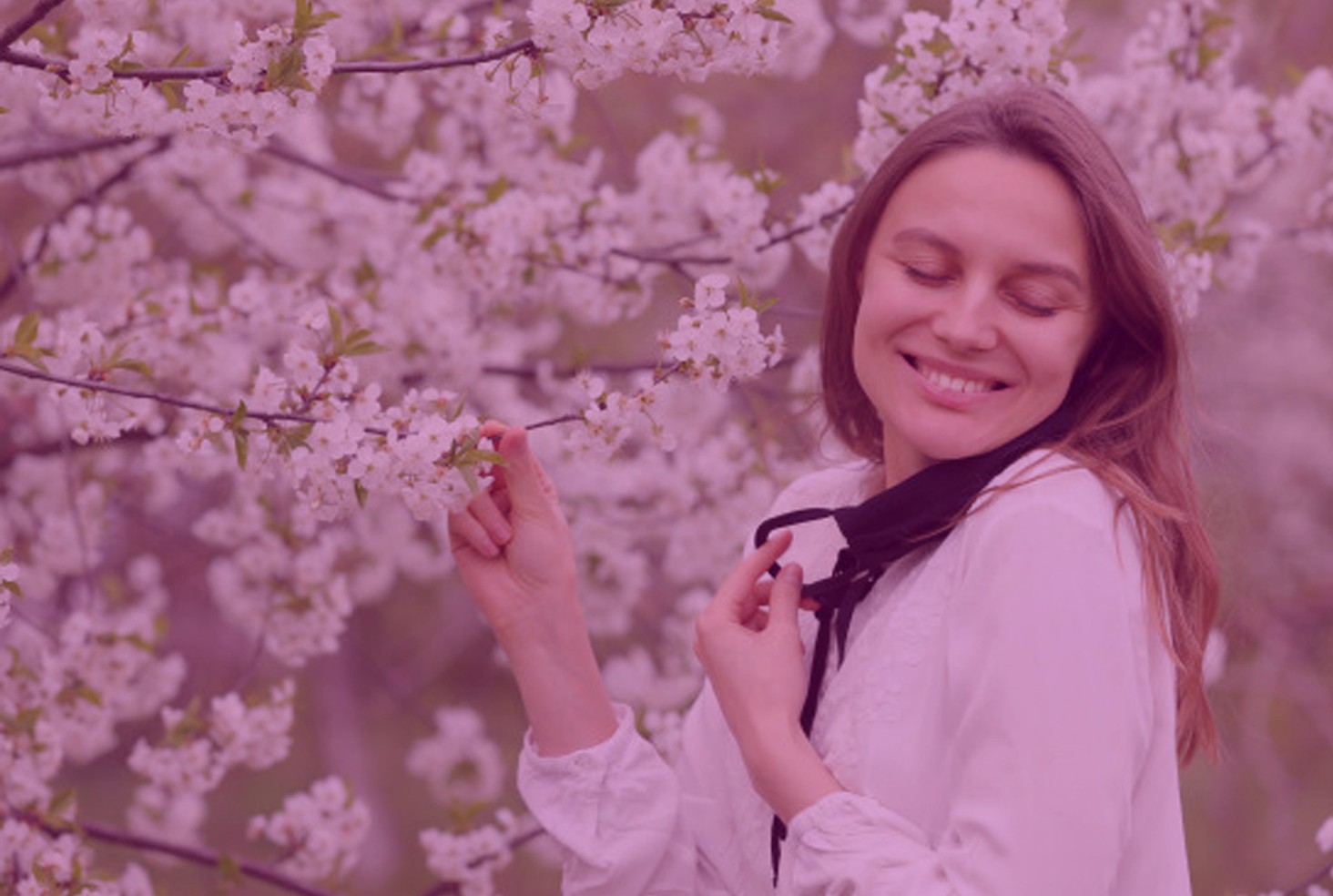 Woman enjoying a calm day outdoors among flowering trees
